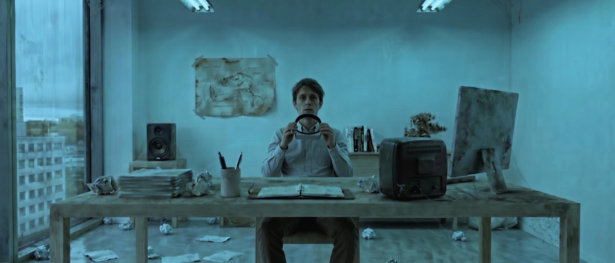 Day two: the same desk, the office decayed and drained to cold blue.